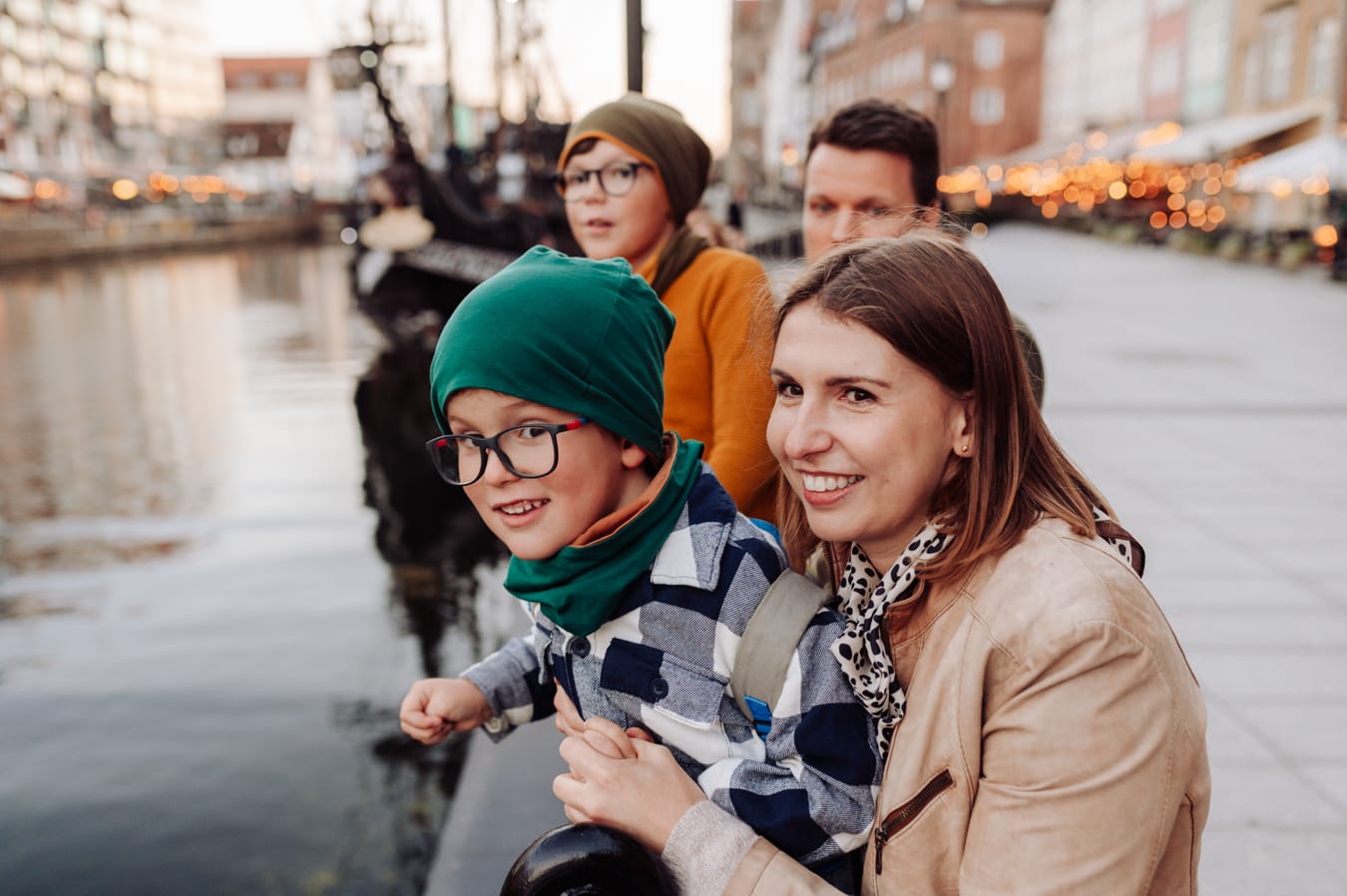 Rodzina opiera się o balustradę przy nabrzeżu podczas miejskiej sesji z dziećmi nad Motławą