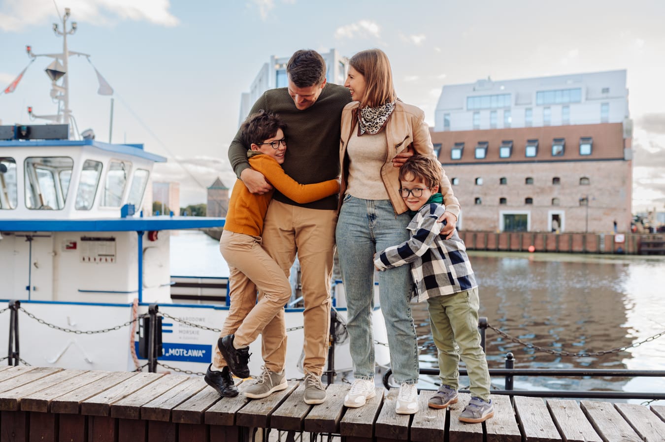 Rodzina z dwoma chłopcami przy Motławie w Gdańsku podczas miejskiej sesji rodzinnej