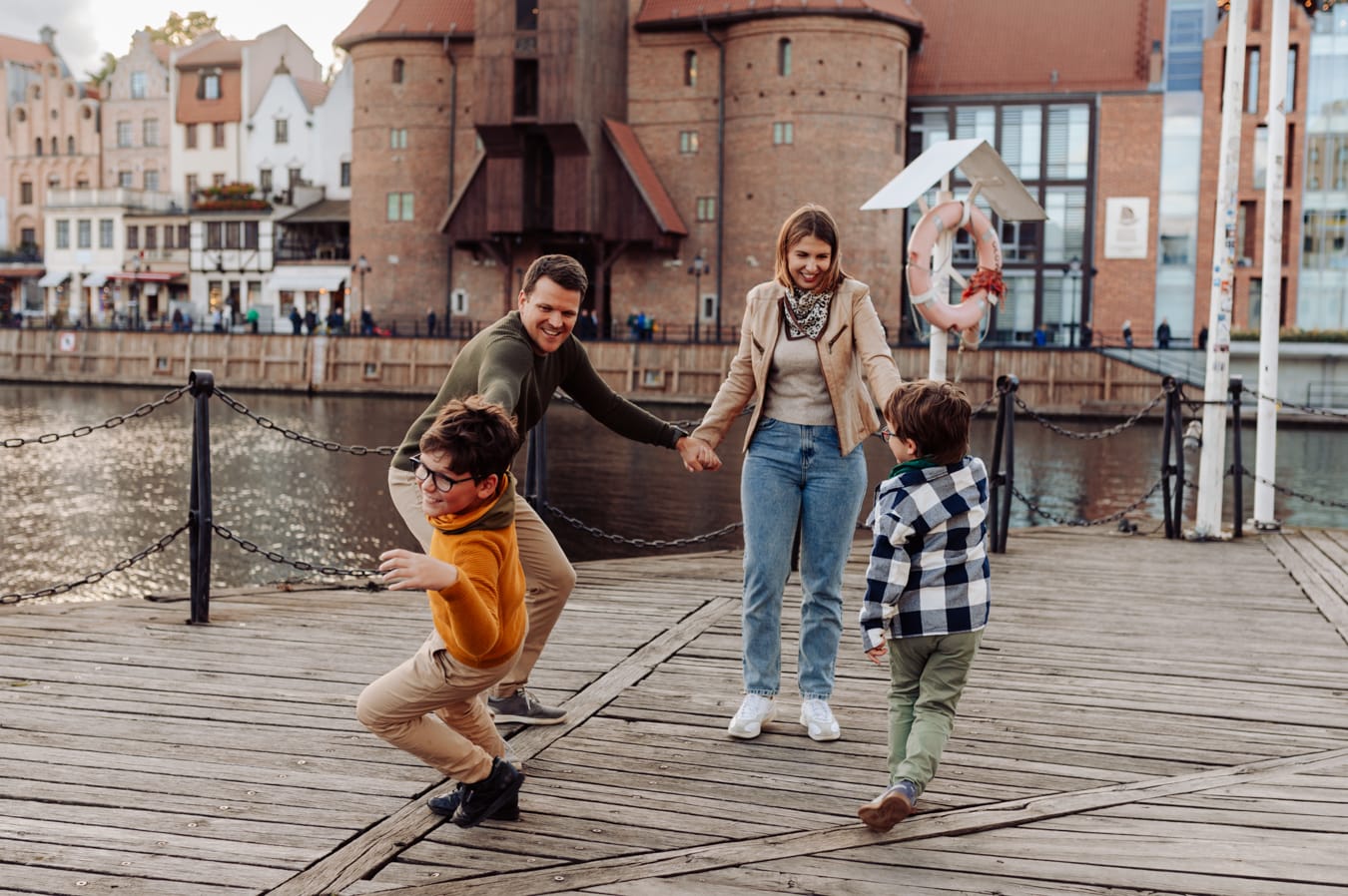 Rodzinne zabawy na tle nabrzeża Motławy w Gdańsku podczas miejskiej sesji rodzinnej.