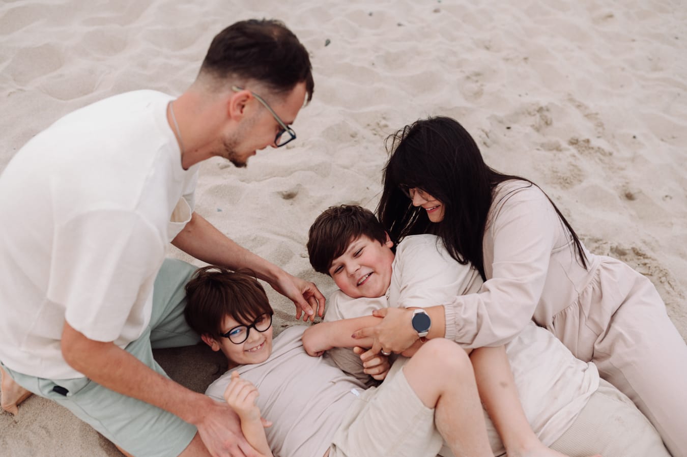 Rodzina łaskotki na plaży sesja z nastolatkami
