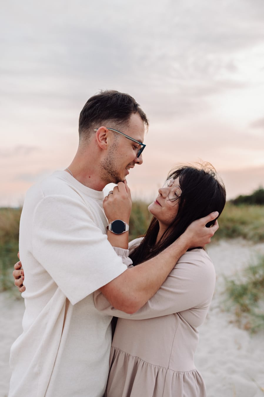 Rodzice wpatrzeni w siebie zachód słońca sesja rodzinna na plaży
