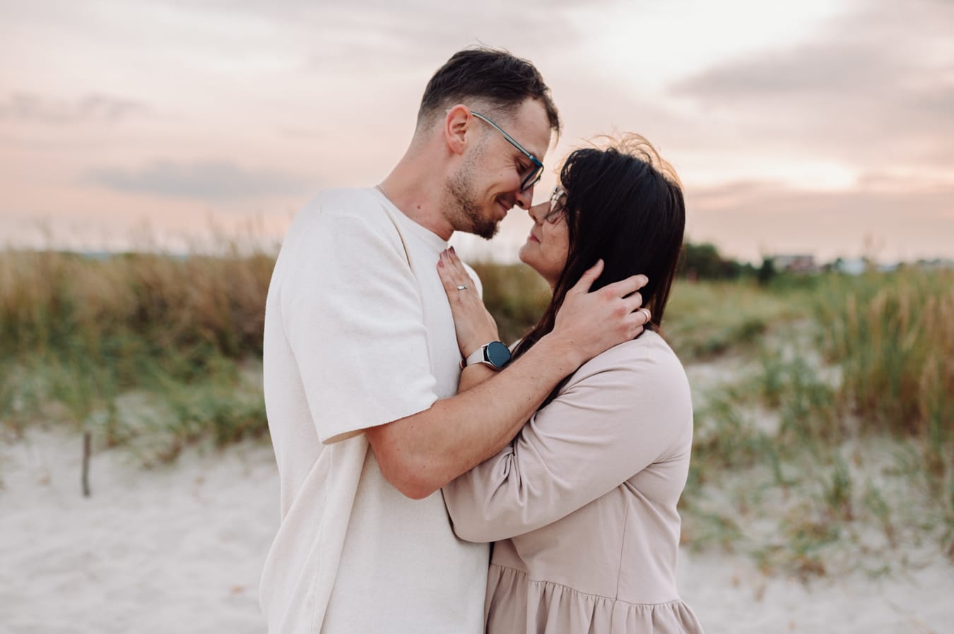 Rodzice przytuleni zachód słońca sesja rodzinna na plaży