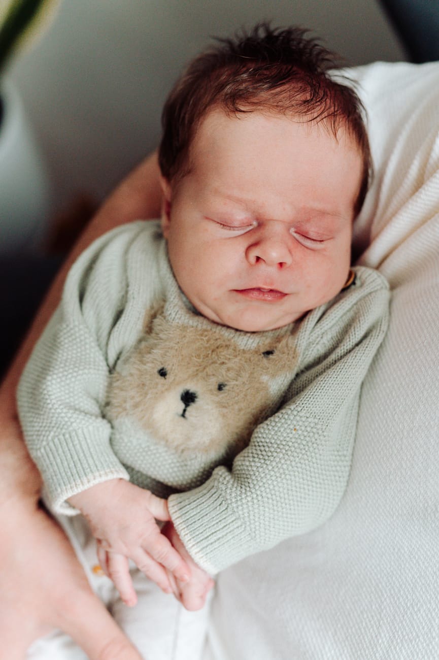 Noworodek w ramionach taty sesja lifestyle w domu Gdynia