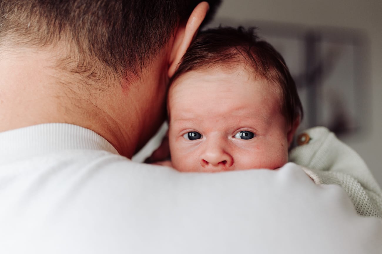 Domowe zdjęcia noworodka mama i tata z maluszkiem na łóżku