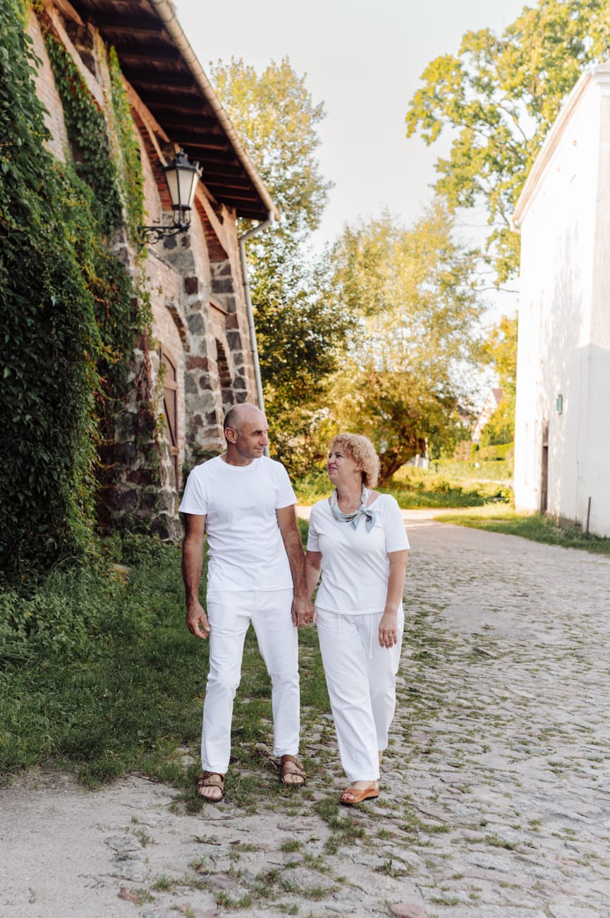 Dojrzała para spaceruje przy stajniach Kolibki sesja rocznicowa