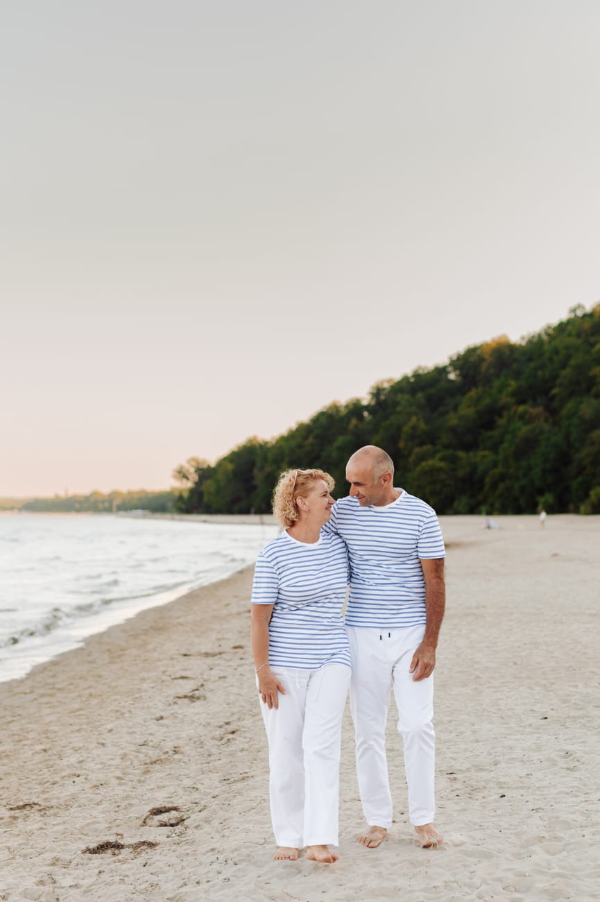 Małżeństwo spaceruje po plaży wieczorne światło sesja Gdynia
