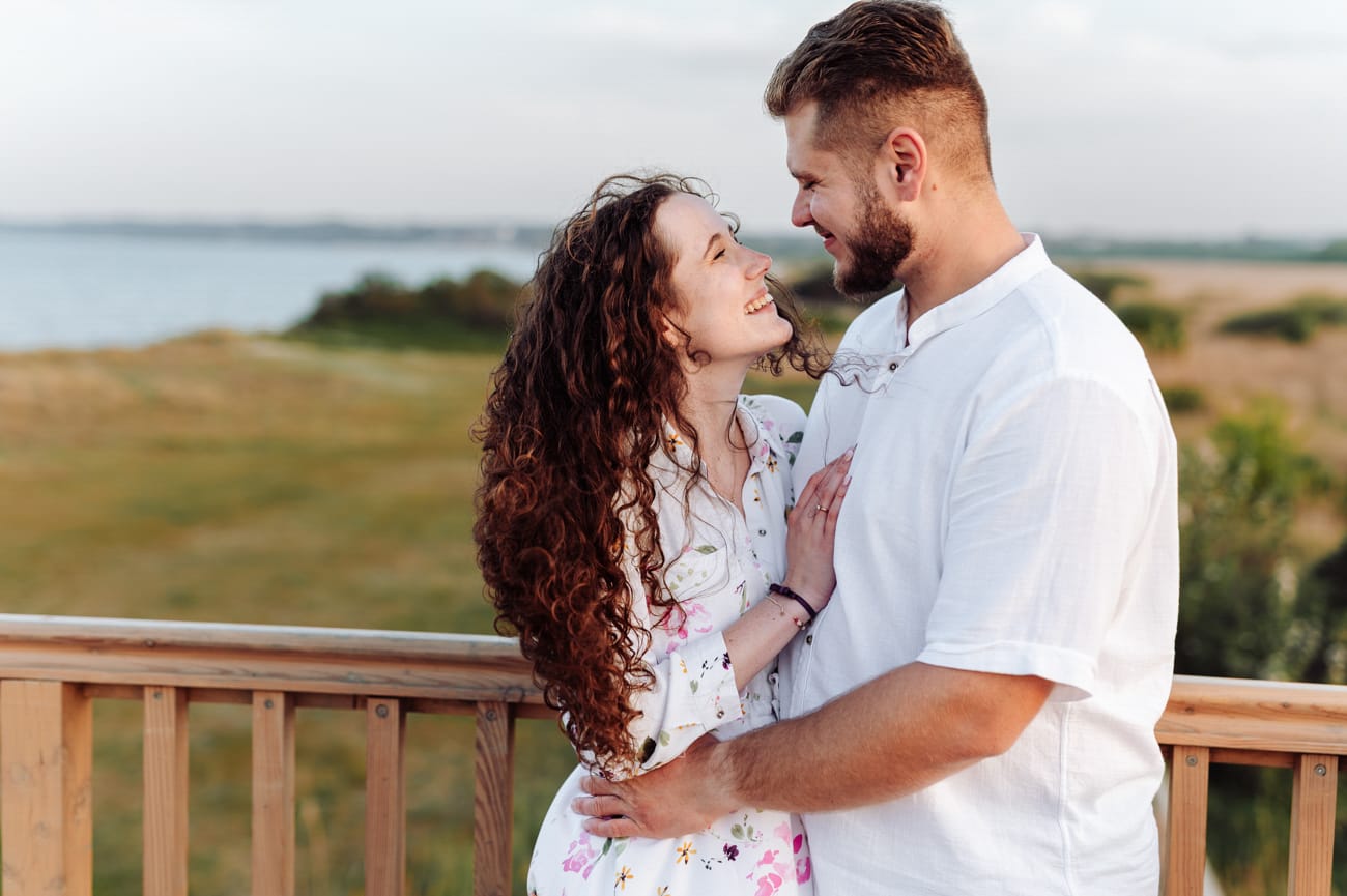 Para wpatruje się w siebie  na kładce do Mechelinek sesja narzeczeńska nad morzem
