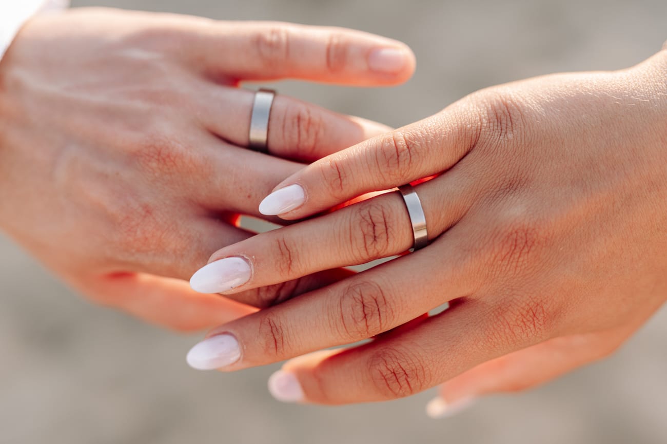 Dłonie nowożeńców z obrączkami sesja poślubna nad morzem Trójmiasto