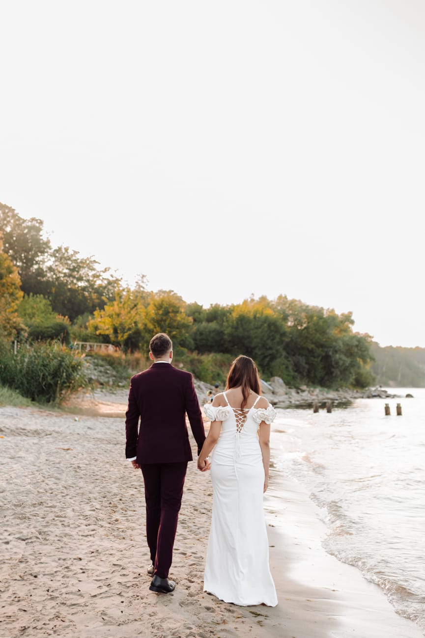 Nowożeńcy spacerują po plaży z psem sesja poślubna Gdynia
