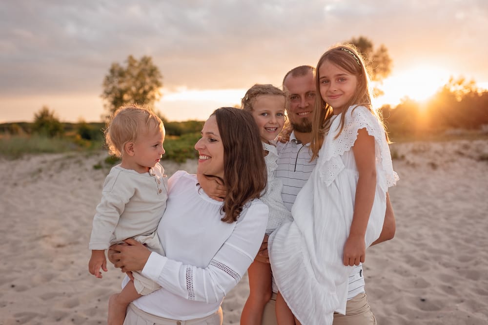 Co ubrać na sesję rodzinną rodzina w stonowanych kolorach na plaży