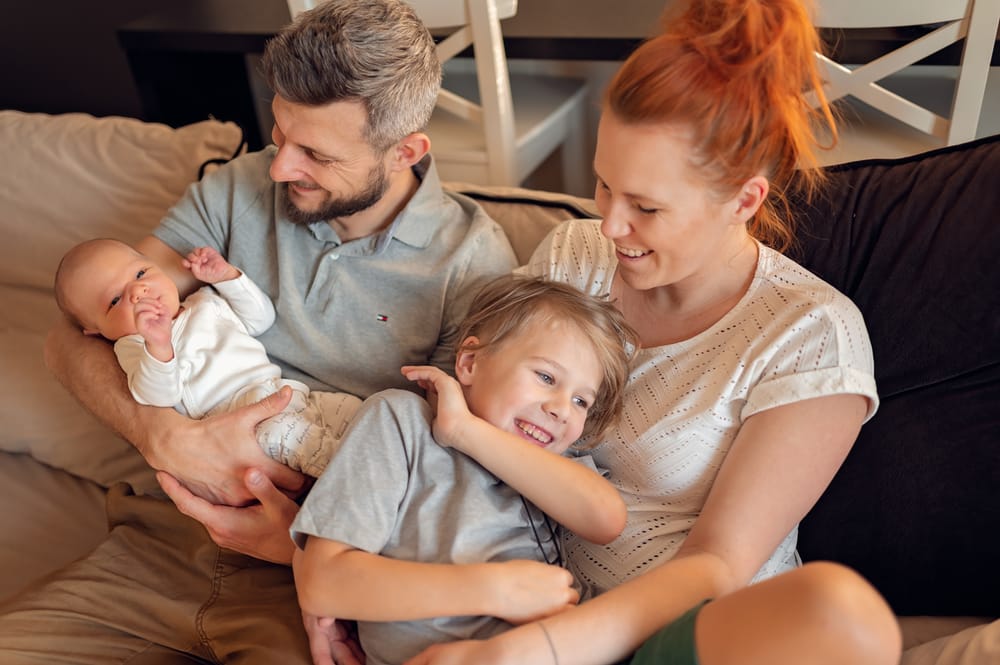 Sesja z noworodkiem w domu Gdańsk rodzina na kanapie