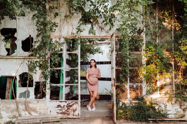 Przyszła mama w szklarni w Orłowie głaszcząca brzuszek — sesja ciążowa Gdynia