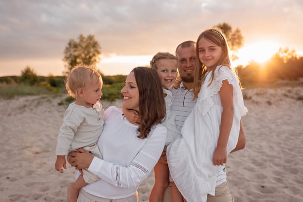 Co ubrać na sesję rodzinną rodzina w stonowanych kolorach na plaży