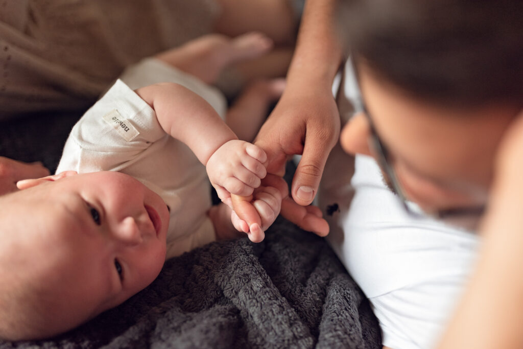 Niemowlę ściskające palec taty.