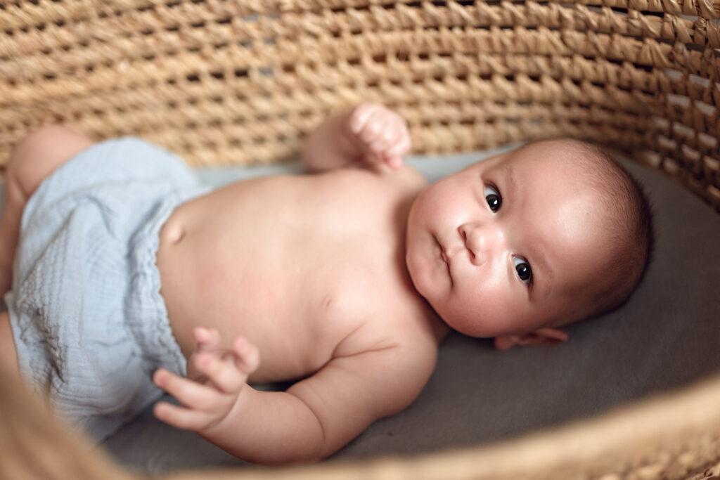 Niemowle wpatrujące się w rodziców leząc w koszu mojżesza. 