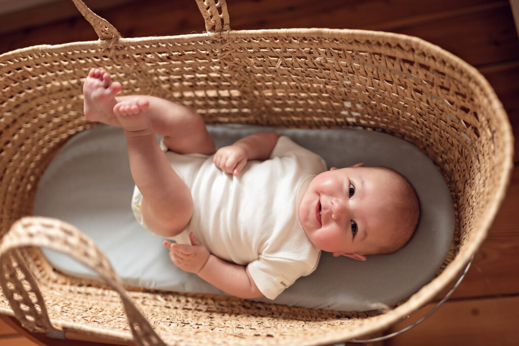 Radosne niemowle leżące w koszu w domowym zaciszu.