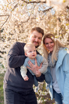 Młoda rodzina wspólnie spędza czas na świeżym powietrzu, ciesząc się pięknem wiosny w Gdyni.