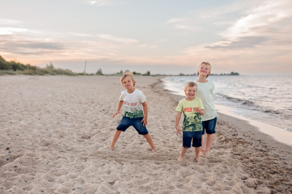 Dzieci bawią się w piasku podczas sesji fotograficznej na plaży nad morzem