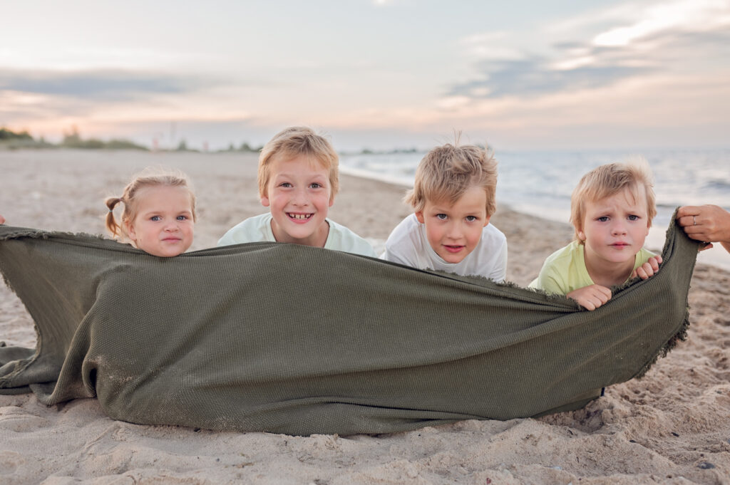 Rodzina cieszy się wspólnym czasem na plaży podczas sesji fotograficznej w Gdyni