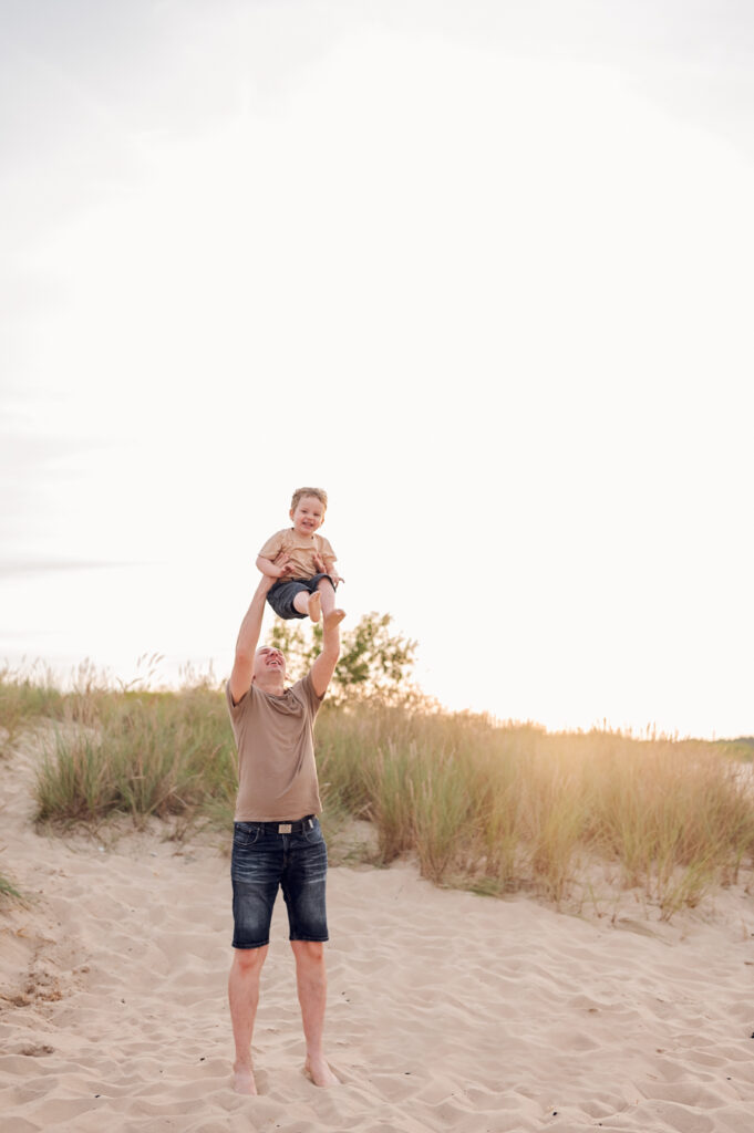 Tata i syn podczas zabawy na rodzinnej sesji nad morzem.