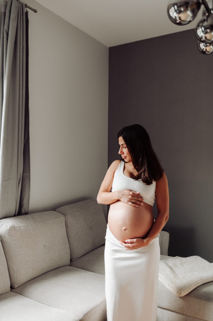 Naturalne światło wpadające przez zasłony oświetla przyszłą mamę