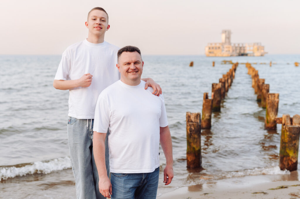 Portret taty i syna na nadmorskiej plaży.