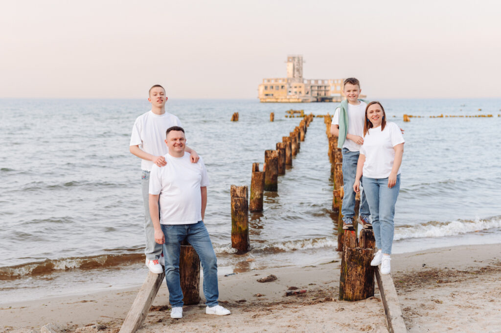 Rodzinny portret nad brzegiem morza z nastoletnimi dziećmi.